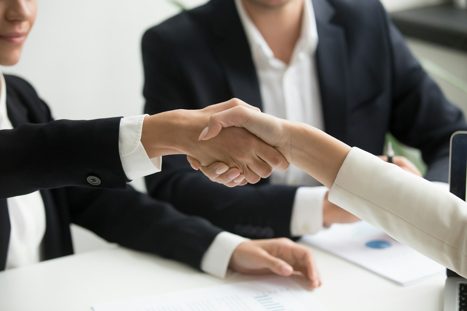 Business partners shaking hands during a technology partnership meeting